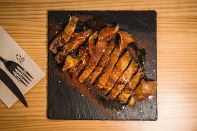 Carne asada cortada y servida sobre pizarra