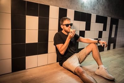 Cliente sentado frente a la pared con el rótulo PIZZA de Porco Dio